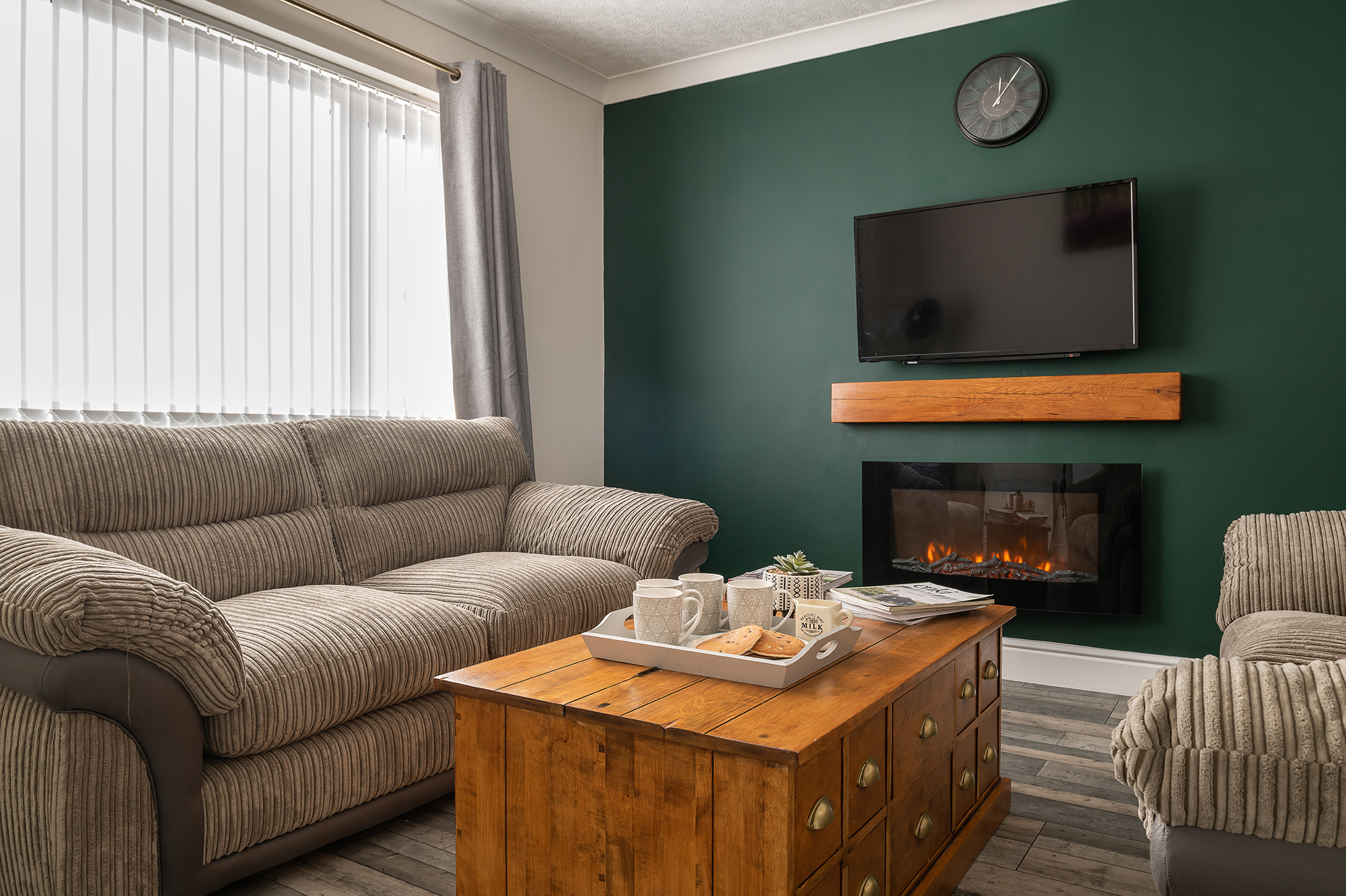Comfortable lounge with fireplace and deep green wall